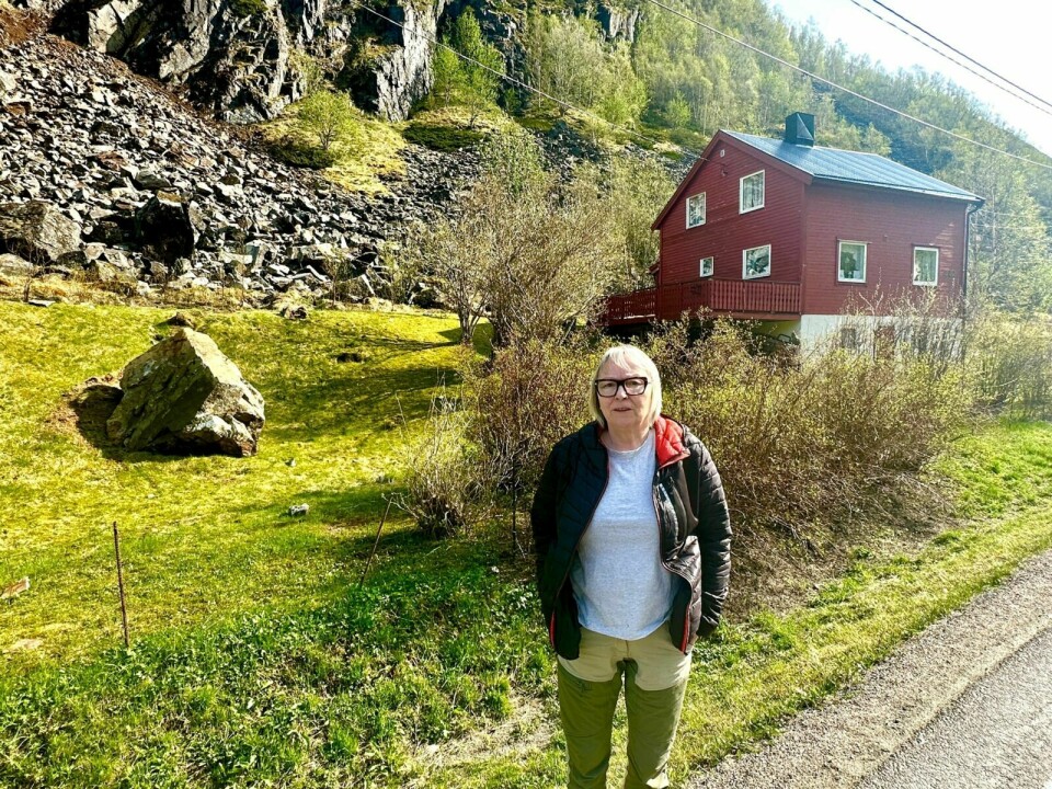 Asveig Andersen foran huset sitt i Spansdalen med raser i bakgrunnen. Foto: Jon Henrik Larsen