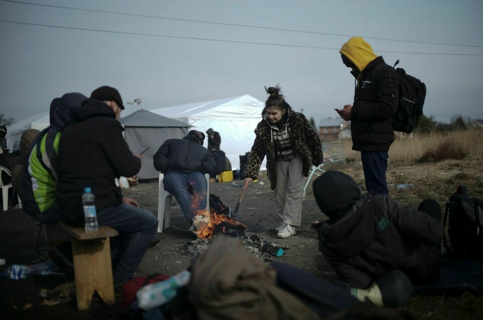 FLYKTNINGER: Flyktninger fra Ukraina tenner et bål ved grensestasjonen ved Medyka i Polen. Foto: AP Photo/Markus Schreiber