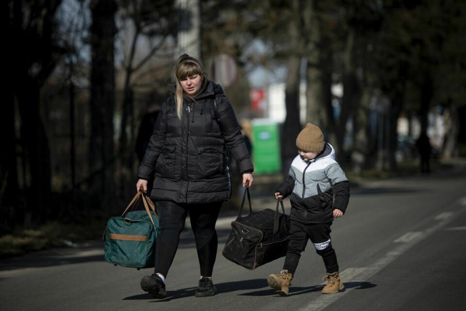 PÅ FLUKT: Et barn og hans mor krysser grensen med Romania, på flukt fra den russiske invasjonen av Ukraina. Foto: Alexandru Dobre / AP / NTB