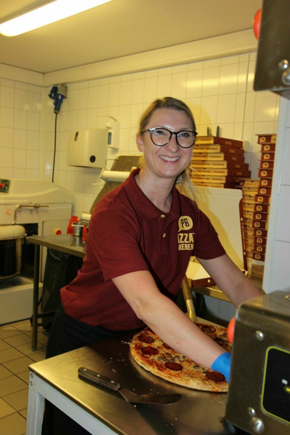 KLAR MED NESTE BESTILLING: Kristina Ilcenkaite er avdelingsleder hos Pizzabakeren. De travleste dagene hos dem er torsdag og søndag, og ellers består kundene for en stor del av soldater. Det meste de selger er som take-away. Foto: Vera Lill Bjørkhaug