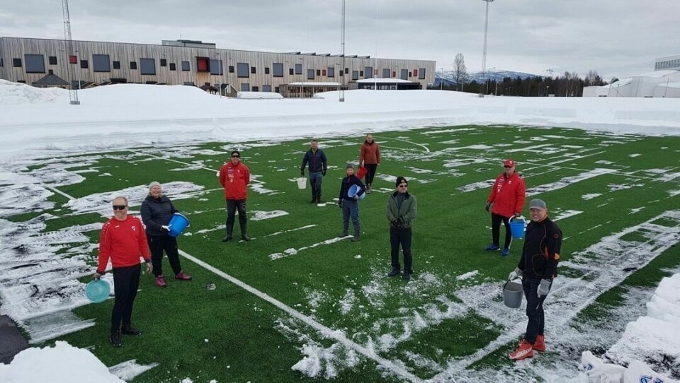 DUGNAD: Søndag var det dugnad med å måke fjerne snø og strø granulat for å sette fart i tineprosessen på fotballanlegget på Rustahøgda. Foto: Stadionstyret BOIF