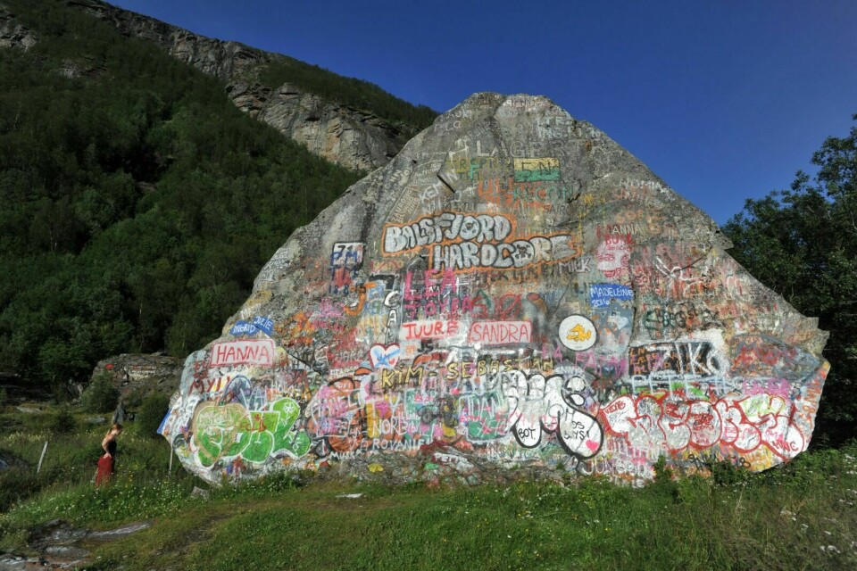 LANDEMERKE: Mange stopper for å beskue eller bidra med egen signatur på denne steinen ved E6/E8. Bildet er tatt i 2016. Foto: TERJE TVERÅS