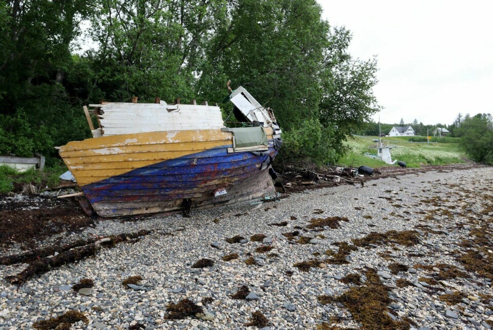 FORLATT: Sjarken og utstyr er forlatt i fjæra ved Seljelvnes, og har ligget der i ett år. Nå ønsker formannskapet i Balsfjord å få den vekk - på eiers regning. Foto: Ivar Løvland