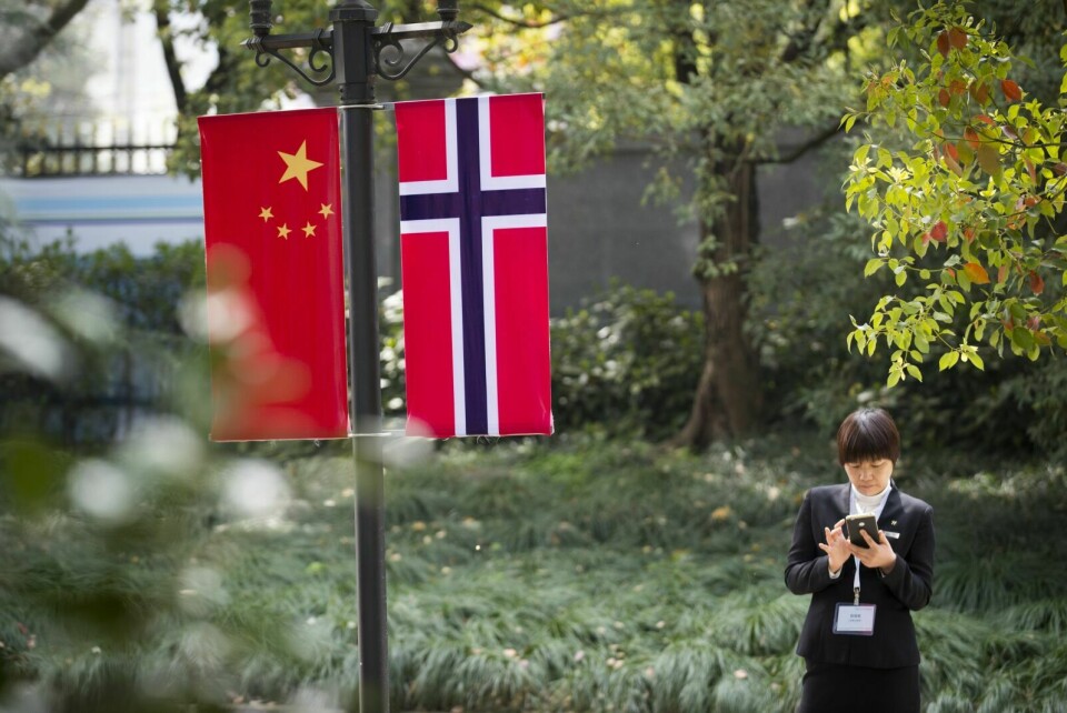 KORTERE REISETID: Det norske og kinesiske flagget i en park i Kina. Sjømat og reiseliv vil få nyte godt av kortere reisetid mellom Troms og Kina når de to flyrutene kommer i drift. Foto: Heiko Junge / NTB scanpix