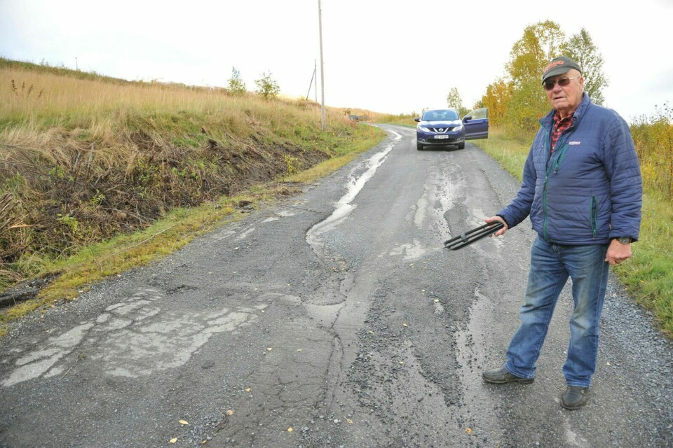 FRUSTRERT: Eilif Harald Engmo er lei av den dårlige veien og mener noe må bli gjort før det blir påført flere skader på kjøretøy. I hånden viser han en av bil-delene han har funnet langs veien.