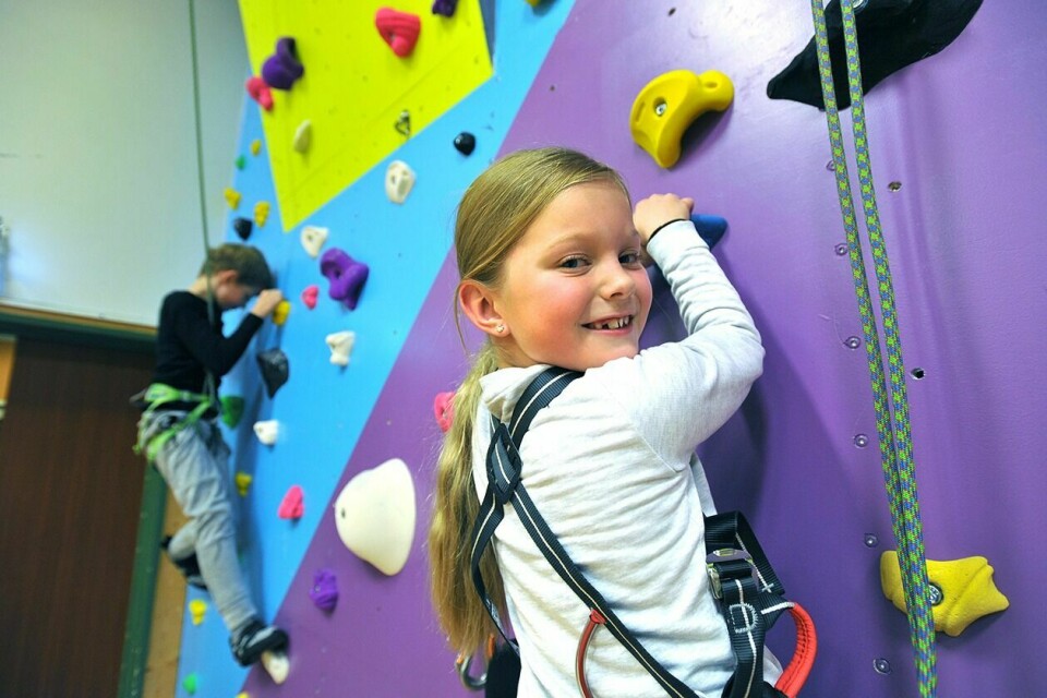 KLATREGLEDE: Astrid ser fram til mye aktivitet i klatreveggen. I bakgrunnen har Denniz fullt fokus på klatringa. Foto: Malin C. S. Myrbakken