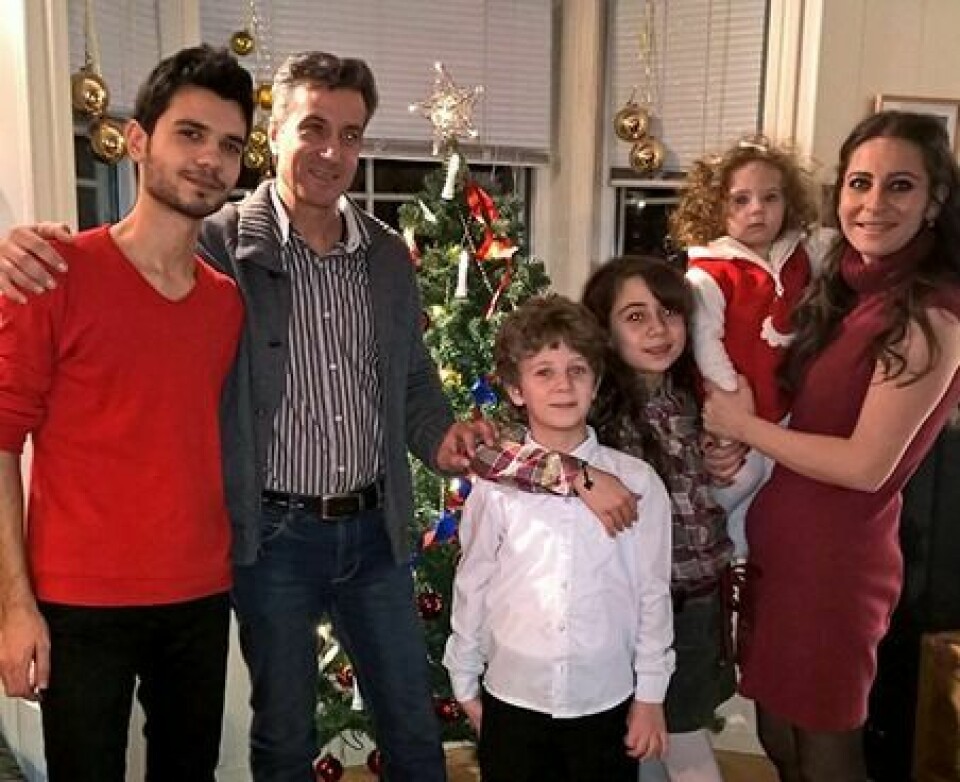 JULEGLEDE: Julaften feiret den syriske familien, her avbildet sammen med en syrisk mann ved navn Abd, hjemme hos Kari Anne Lundberg og hennes familie. Da var det smil og glede hos dem alle. Foto: Privat.