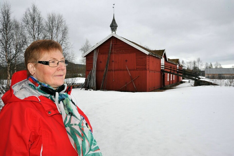 VIL STOPPE FORFALL: Leder Anne Berit Fosli i Støtteforeninga for Fossmotunet ønsker at Troms fylkeskommune skal bidra med mer penger til vedlikehold av bygningene på bygdetunet. I bakgrunnen Sandeggen-fjøset, som ble flyttet fra Kirkesdalen til Fossmotunet på første halvdel av 1980-tallet.