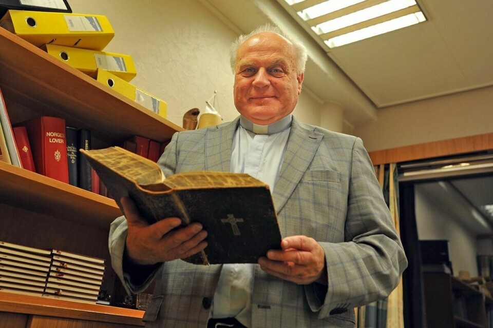 FOLKEPROSTEN: Han har noen eldgamle bibler på kontoret sitt, Hans Erik Holm. Og han liker å drive kirka på gammelmåten, nemlig ute der folk er. Det er med å bidra til at svært mange ser han som selve bilde på folkekirka. Foto: Kari Anne Skoglund