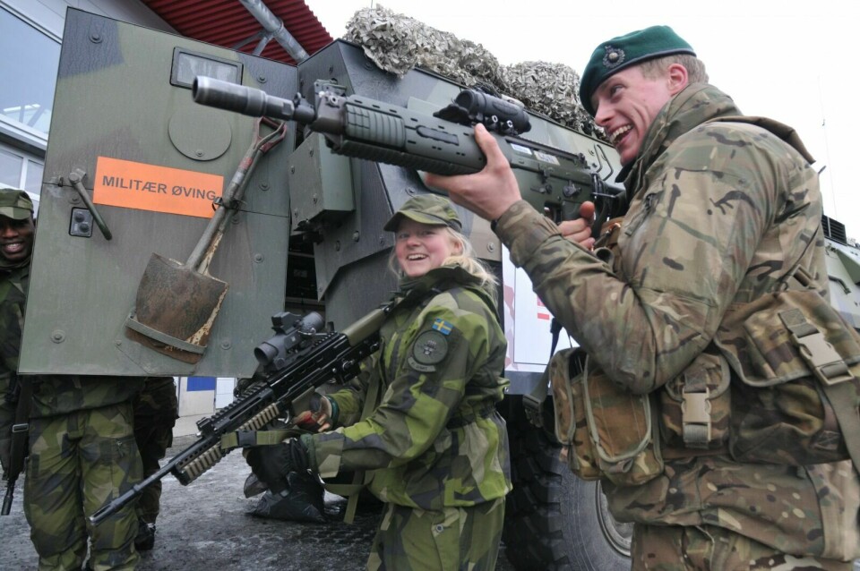 FRA NORD-SVERIGE: Broderfolket deltar også under øvelsen, her representert ved ei svensk flicka från Norrbotten Brigade og en annen utenlandsk soldat som vil prøve de svenske våpnene. Foto: Terje Tverås