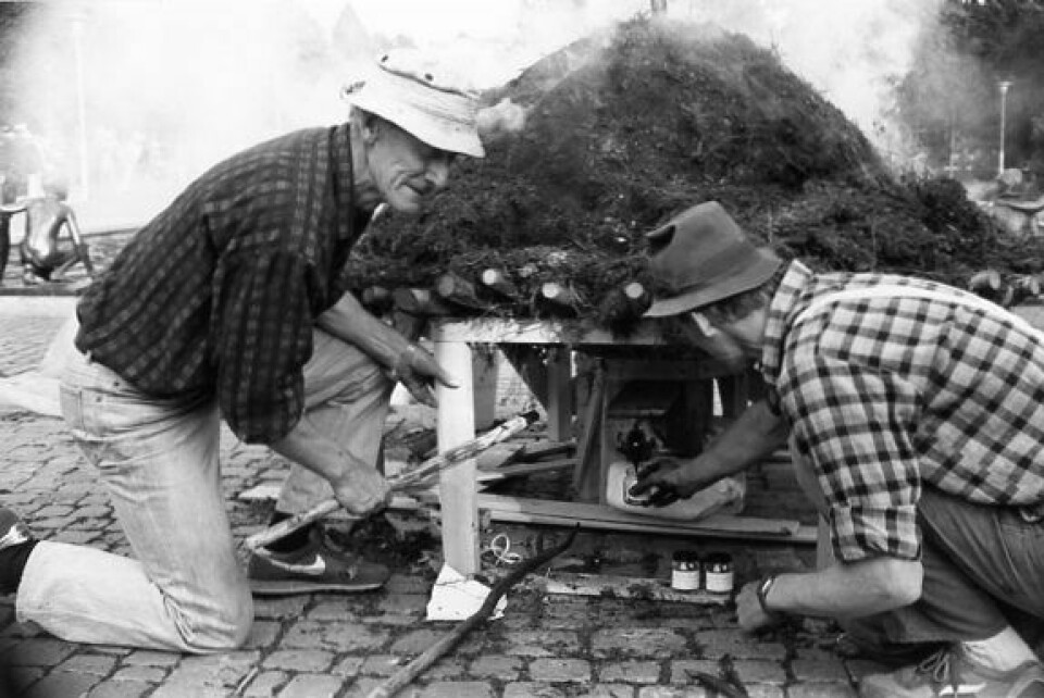 RØYKLA SPIKERSUPPA: Andreas Eldnes og Otto Nesvik tente på tjæremila i Spikersuppa under det kombinerte 50- og 200-årsjubileumet i 1988. Foto: Privat